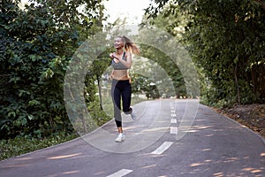 Woman running asphalt road summer park