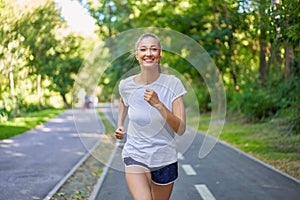 Woman running asphalt road summer park