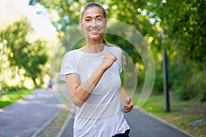 Woman running asphalt road summer park