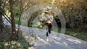 Woman running asphalt road summer park