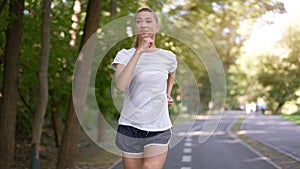 Woman running asphalt road summer park
