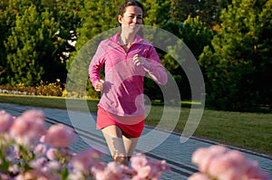 Woman running in autumn park, beautiful girl runner jogging outdoors