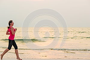 Woman running barefoot on the beach