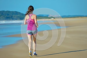 Woman running on beach, beautiful girl runner jogging