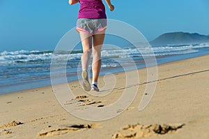 Woman running on beach, girl runner jogging outdoors