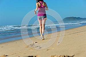 Woman running on beach, girl runner jogging outdoors