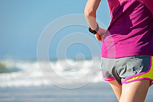 Woman running on beach, girl runner jogging outdoors