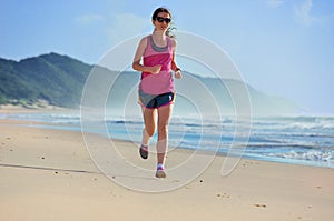 Woman running on beach, girl runner jogging outdoors