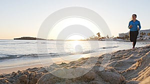 Woman running on beach at sunset