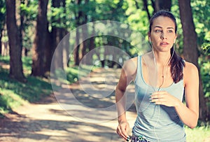 Woman running In countryside wearing earphones