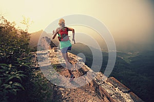 Woman running at great wall on the top of mountain