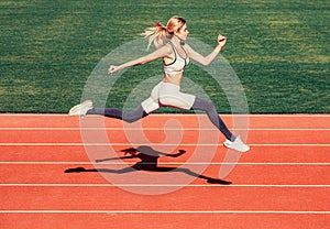 Woman running jump on stadium track. Sportswoman in sportswear jumping. Woman running during. Sport backgrounds. Runner