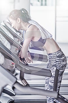 Woman running in machine treadmill at fitness gym