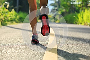 woman running on morning tropical forest trail