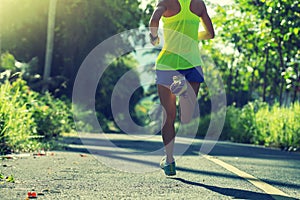 woman running on morning tropical forest trail