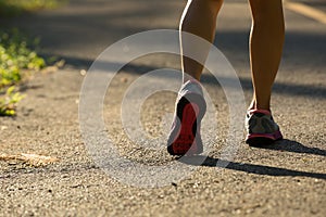 Woman running on morning tropical forest trail