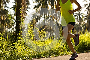 woman running on morning tropical forest trail