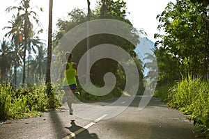 woman running on morning tropical forest trail