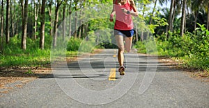 woman running at morning tropical forest trail