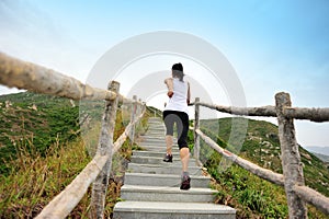 Woman running at mountain stairs