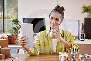 Woman Running Online Business Making Boutique Candles At Home Having Video Call On Digital Tablet