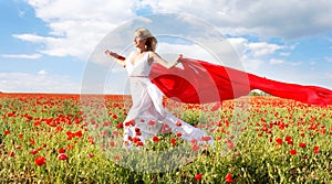 Woman running with red scarf in poppy field