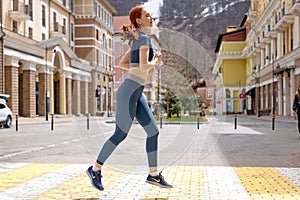 Woman running on road in city. Lifestyle morning run. Fitness and healthy lifestyle