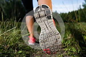 Woman and running shoes in forest, exercising