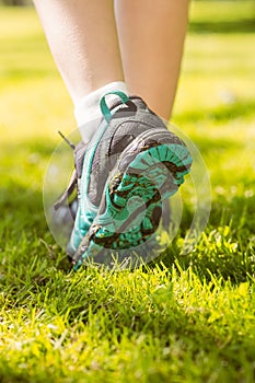 Woman in running shoes stepping on grass