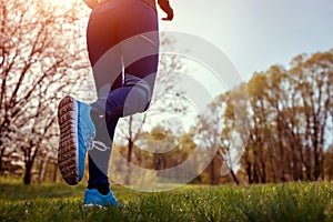 Woman running in spring forest. Close-up of sneakers. Helathy lifestyle concept. Active sportive people