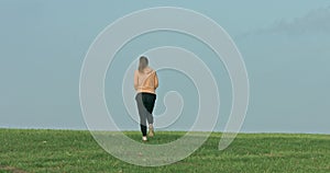 Woman running on spring green grass