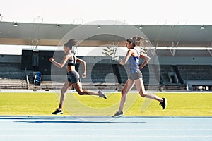 Woman, running and stadium track in competition, race or fitness for athletics in the outdoors. Fit, active or sporty