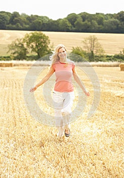 Woman Running Through Summer Harvested Field