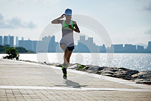 Woman running on sunny coast