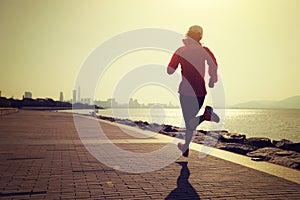 Woman running on sunny coast road