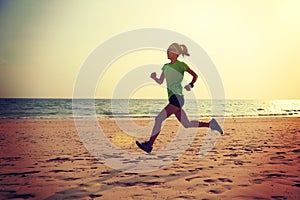 Woman running on sunrise sandy beach
