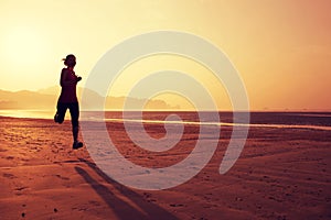 Woman running on sunrise sandy beach