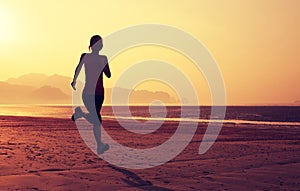 woman running on sunrise sandy beach