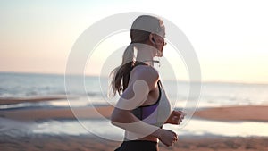 Woman running sunrise sun light sea beach healthy lifestyle outdoor physical activity slowmo