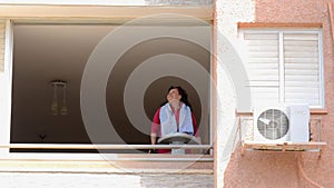 Woman running on a treadmill in front of opened window