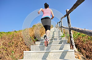 Woman running up on mountain stairs