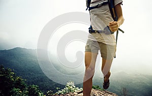 woman running up on the mountain top cliff edge