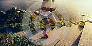 woman running up on seaside mountain stairs