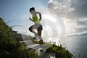 woman running up on seaside mountain stairs