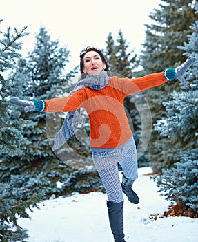 Woman is running in winter forest, beautiful landscape with snowy fir trees