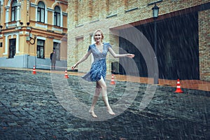 Woman runs barefoot on the road in the rain