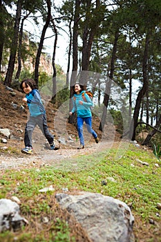 A woman runs with a child on a forest road