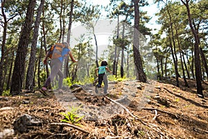 A woman runs with a child on a forest road