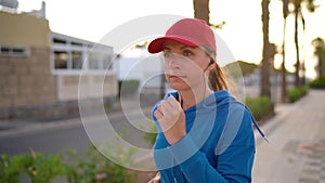 Woman runs down the street along the palm avenue at sunset. Healthy active lifestyle. Slow motion