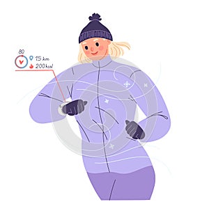 Woman runs outside in winter and looks at smart watch checking her heart rate, pulse, calories, distance.